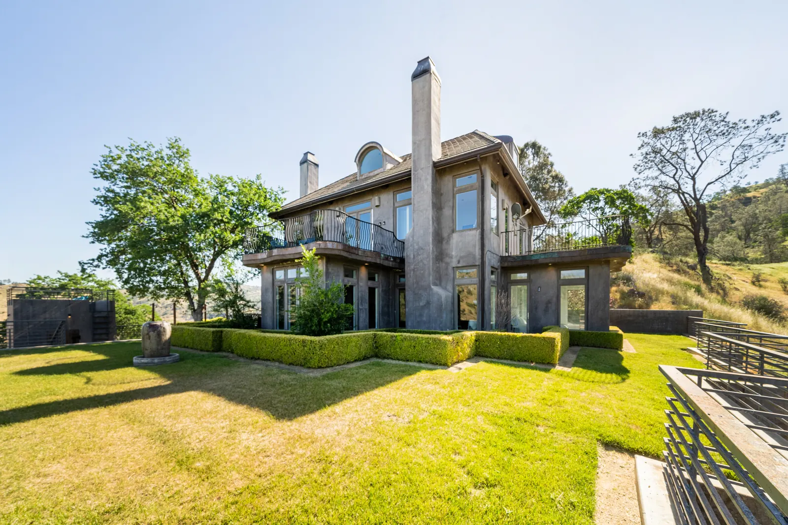 Wide view of the lawn and the back of the three-level house